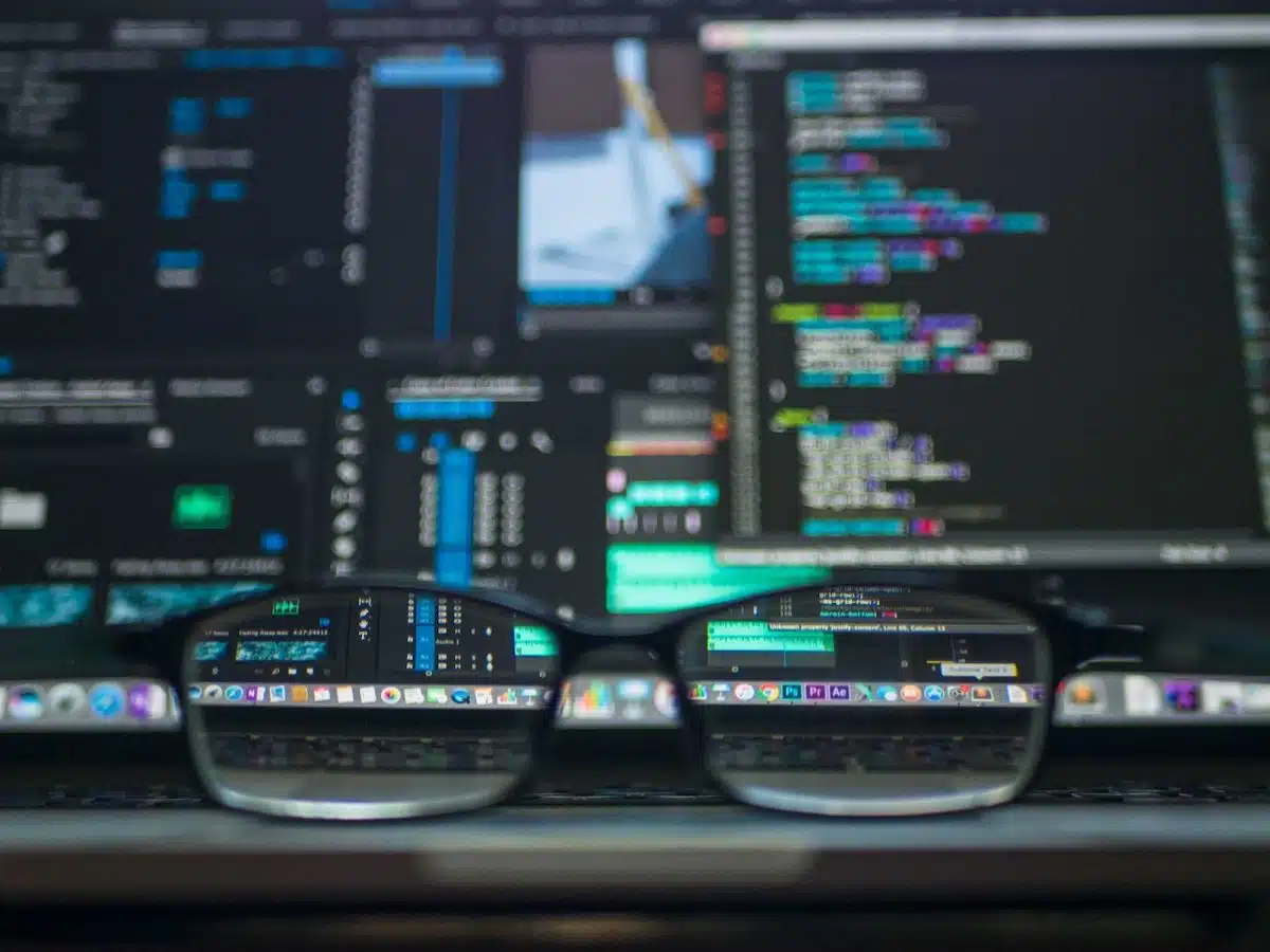 lunettes devant du code affiché sur un écran d'ordinateur