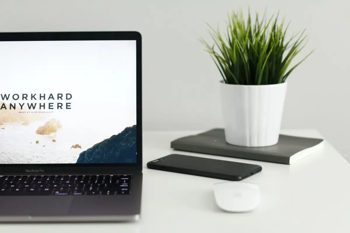 MacBook Pro near green potted plant on table